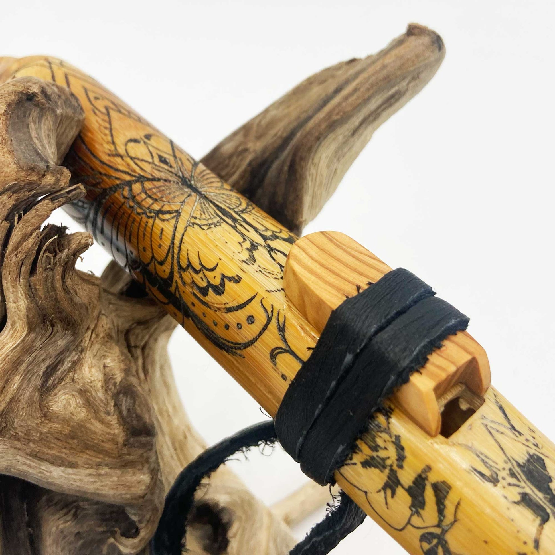 Flûte amérindienne en bambou Mi 432Hz gravée d’un attrape-rêve, papillon et lotus, avec totem en noyer et lacet cuir noir.