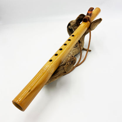 Flûte amérindienne professionnelle en bambou brillant (Shellawax), accordée en Sol 432Hz. Focus sur le totem sculpté en padouk et l'embouchure ergonomique. Instrument de concert.