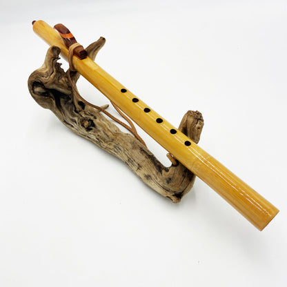 Flûte amérindienne professionnelle en bambou brillant (Shellawax), accordée en Sol 432Hz. Focus sur le totem sculpté en padouk et l'embouchure ergonomique. Instrument de concert.