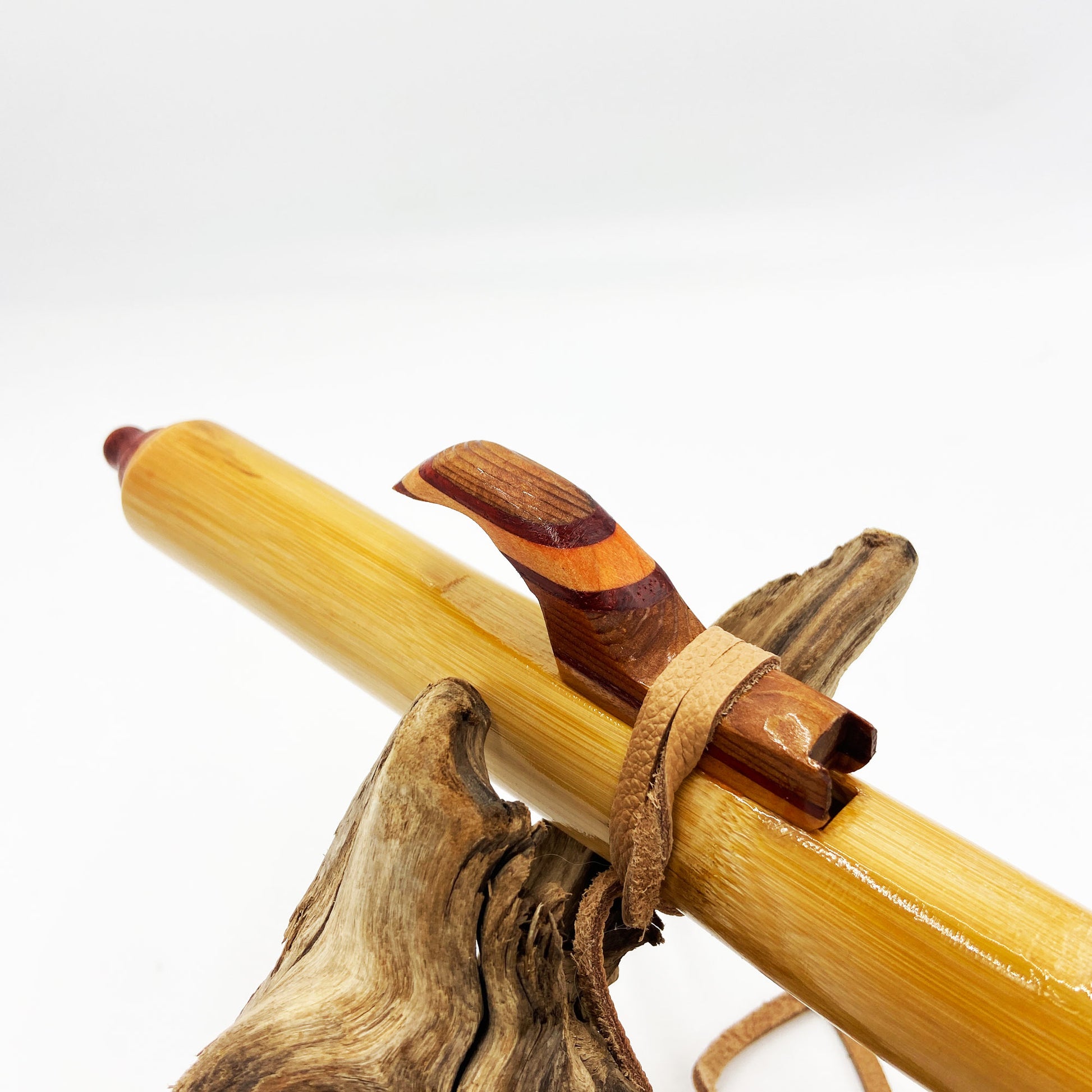 Flûte amérindienne professionnelle en bambou brillant (Shellawax), accordée en Sol 432Hz. Focus sur le totem sculpté en padouk et l'embouchure ergonomique. Instrument de concert.