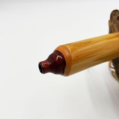 Flûte amérindienne professionnelle en bambou brillant (Shellawax), accordée en Sol 432Hz. Focus sur le totem sculpté en padouk et l'embouchure ergonomique. Instrument de concert.