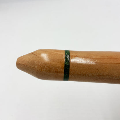 Flûte amérindienne artisanale en bois de cèdre clair, totem en noyer, ornements plumes violettes et turquoises, posée sur un support en bois flotté naturel.