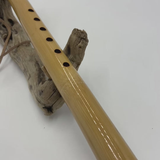 Flûte amérindienne professionnelle en bambou brillant (Shellawax), accordée en Sol 432Hz. Focus sur le totem sculpté en padouk et l'embouchure ergonomique. Instrument de concert.
