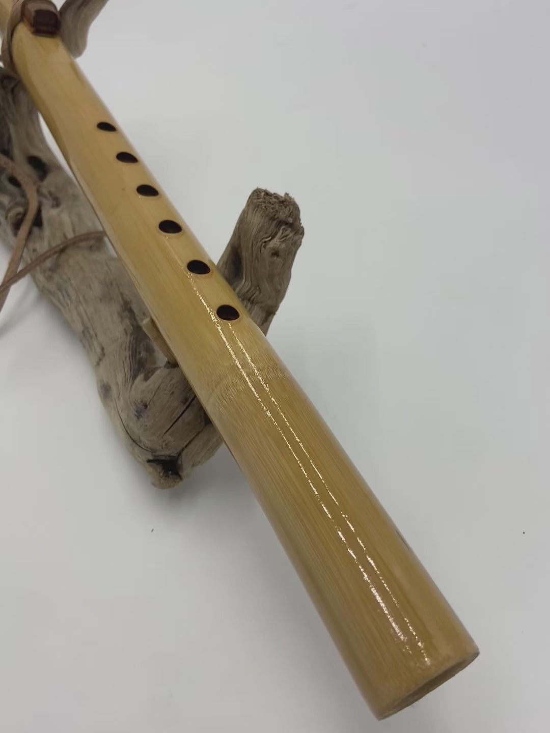 Flûte amérindienne professionnelle en bambou brillant (Shellawax), accordée en Sol 432Hz. Focus sur le totem sculpté en padouk et l'embouchure ergonomique. Instrument de concert.